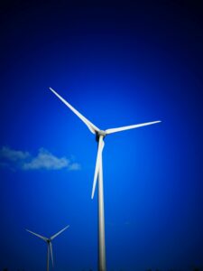 Wind turbines generating clean energy under a bright blue sky.